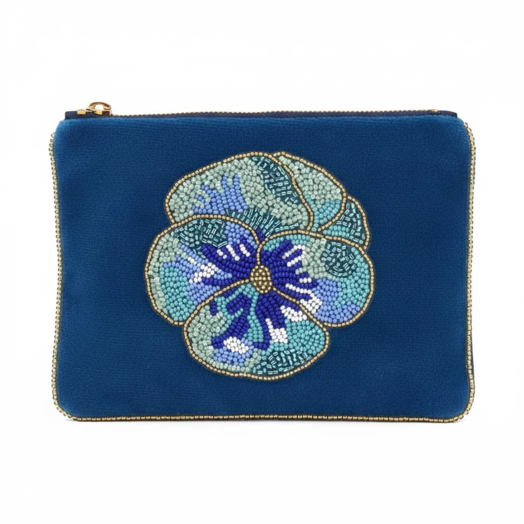 A blue velvet zippered pouch featuring a large, detailed beaded pansy flower in shades of blue, purple, and white on the front, finished with gold trim.