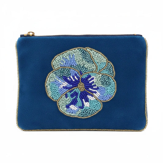 A blue velvet zippered pouch featuring a large, detailed beaded pansy flower in shades of blue, purple, and white on the front, finished with gold trim.