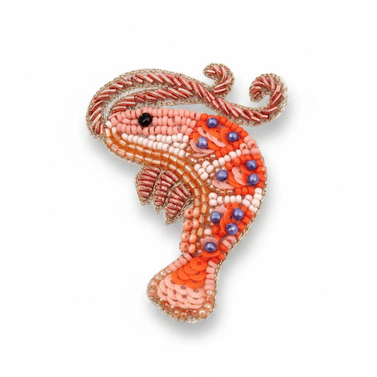 Decorative seahorse ornament with bead details on a white background